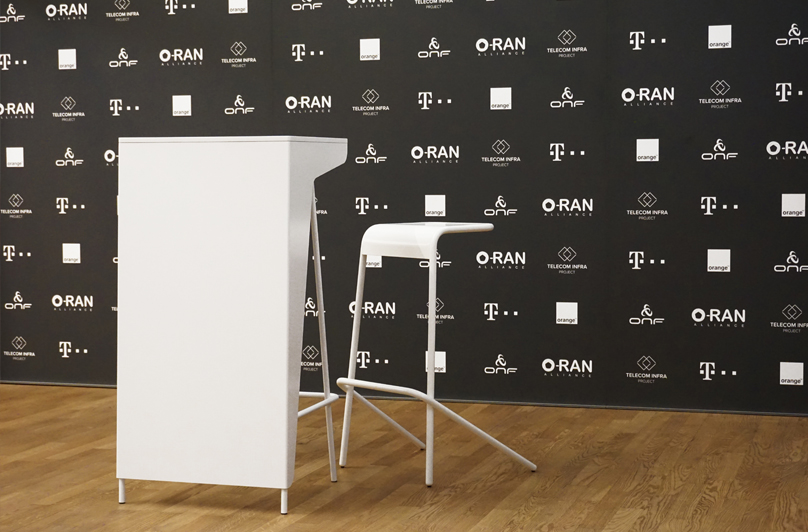 Rednerpult und Stehhocker vor Logowall